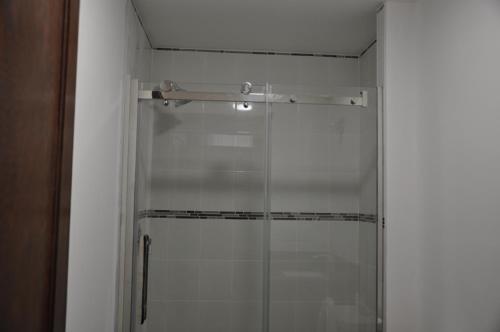 a shower with a glass door in a bathroom at Ambassador's Inn Next Door in Stratford