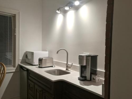 a kitchen with a sink and two appliances on a counter at Ambassador's Inn Next Door in Stratford