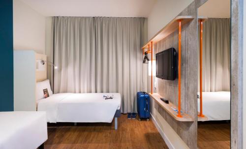 a hotel room with two beds and a tv at ibis budget Navegantes Itajai in Itajaí