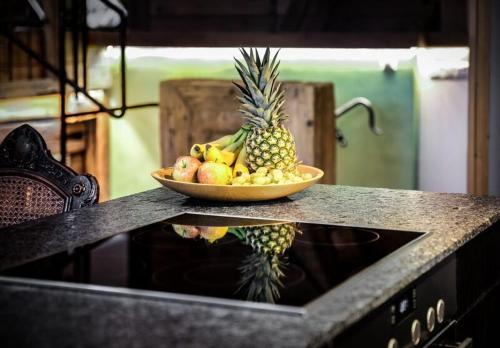 a bowl of fruit on a counter with a bowl of pineapple at Altstadt-Loft Füssen in Füssen