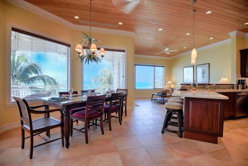 a dining room with a table and some chairs at Cape Santa Maria Beach Resort & Villas in Seymourʼs