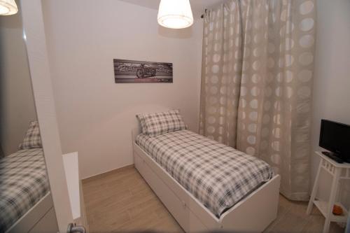 a small room with a bed and a television at Borgo Antico Home in Poggiorsini