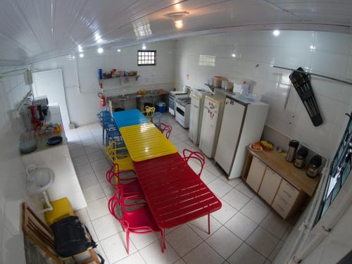 uma vista superior de uma cozinha com uma mesa vermelha e amarela em Eco Box Hostel em Florianópolis