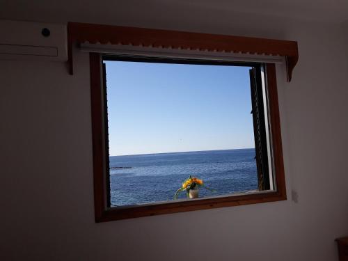 a window in a room with a view of the ocean at 777 Beach Guesthouse in Paphos City