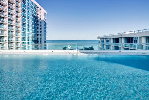 a large swimming pool in front of two tall buildings at Carillon Miami Wellness Resort in Miami Beach