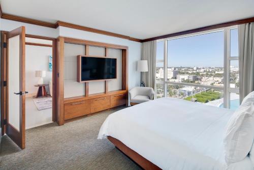 a bedroom with a large bed and a large window at Carillon Miami Wellness Resort in Miami Beach