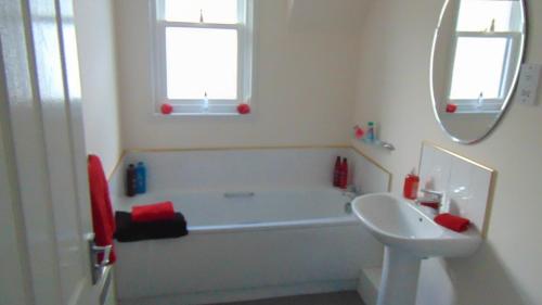 een badkamer met een bad, een wastafel en een spiegel bij Montclaire in Ballater
