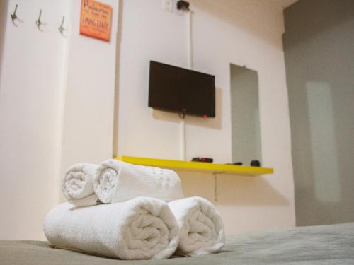 un mucchio di asciugamani in una stanza con televisore di Che Lagarto Hostel Morro De São Paulo a Morro de São Paulo