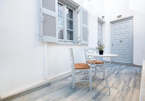 un tavolo e sedie sul portico di una casa di MerSea apartments a Paroikia