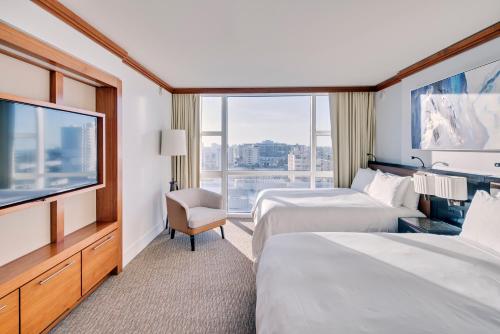 a hotel room with two beds and a flat screen tv at Carillon Miami Wellness Resort in Miami Beach