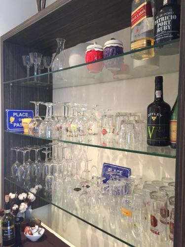a shelf filled with glasses and bottles of wine at B&B Sabbajon in Ypres