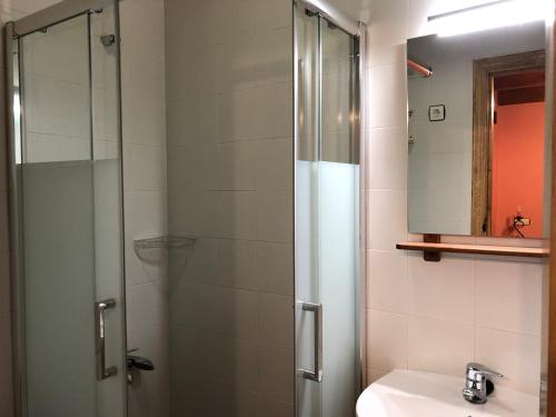 y baño con ducha acristalada y lavamanos. en Hotel Rural El Lagar De Las Médulas, en Orellán