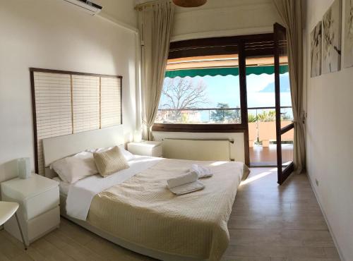 ein Schlafzimmer mit einem großen Bett und einem großen Fenster in der Unterkunft Cadenabbia Fantastico in Griante Cadenabbia