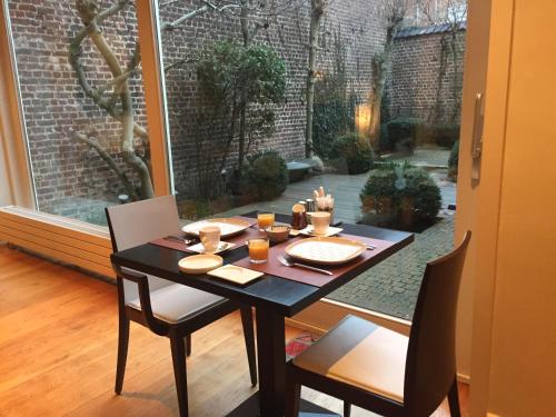 a dining room table and chairs with a view of a courtyard at B&B Sabbajon in Ypres