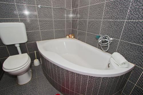 a bathroom with a white tub and a toilet at Apartman Maja in Vodice