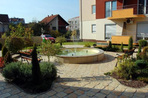 a garden with a small pool in the middle of a yard at IWA CENTAR Apartments & Wellness in Vrnjačka Banja