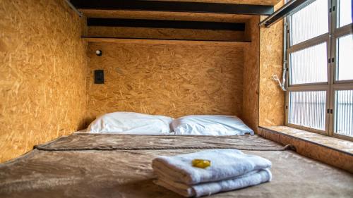 a bed sitting in a room with a window at Eco Box Hostel in Florianópolis