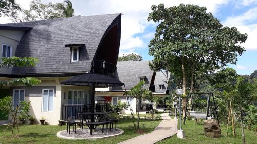 a house with a picnic table and an umbrella at The Duyan House at Sinagtala Resort in Orani