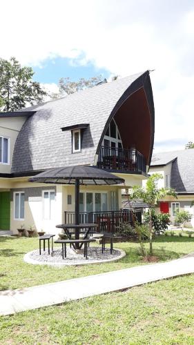 a house with a picnic table and an umbrella at The Duyan House at Sinagtala Resort in Orani