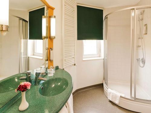 La salle de bains est pourvue d'un lavabo vert et d'une douche. dans l'établissement Ibis Eskisehir, à Eskişehir