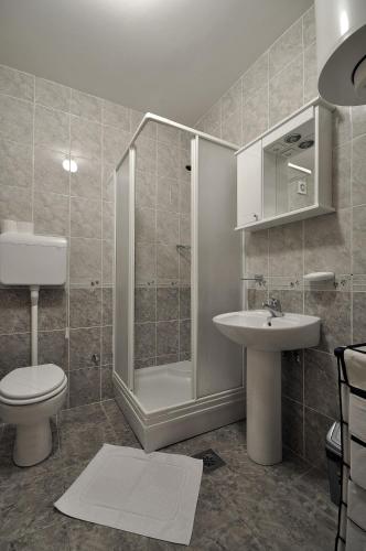 a bathroom with a shower and a toilet and a sink at IWA CENTAR Apartments & Wellness in Vrnjačka Banja