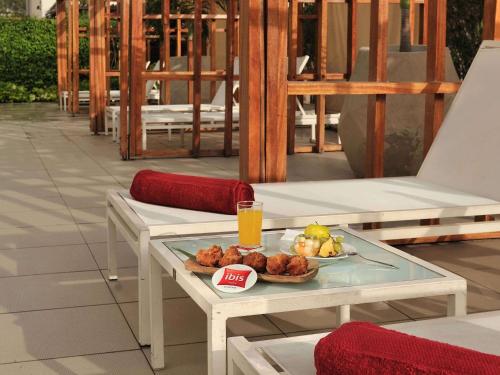 a table with a plate of food and a drink at Ibis Dakar in Dakar