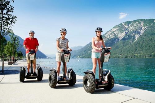 three people riding on segifts next to a lake at Appartement Frühstückspension Landhaus Karwendel in Pertisau