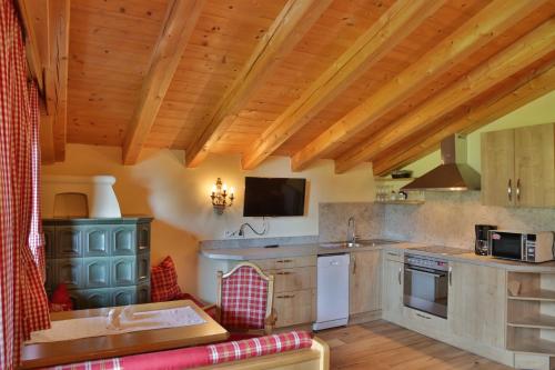 a large kitchen with wooden ceilings and wooden counters at Appartement Frühstückspension Landhaus Karwendel in Pertisau