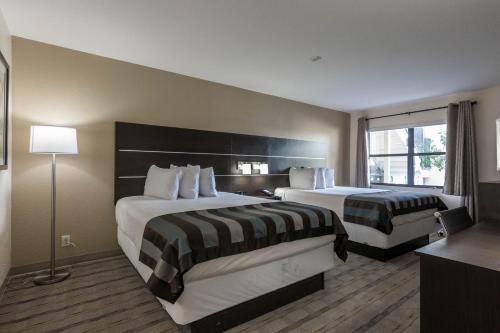 a hotel room with two beds and a window at Baymont by Wyndham Punta Gorda/Port Charlotte in Punta Gorda