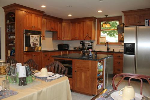 a kitchen with wooden cabinets and a stainless steel refrigerator at Northey Street House in Salem