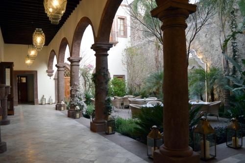 an arcade with tables and chairs in a restaurant at Hotel Casa Blanca 7 in San Miguel de Allende