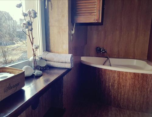 a bathroom with a tub and a sink and a window at Apartament Szczawno-Zdrój in Szczawno-Zdrój