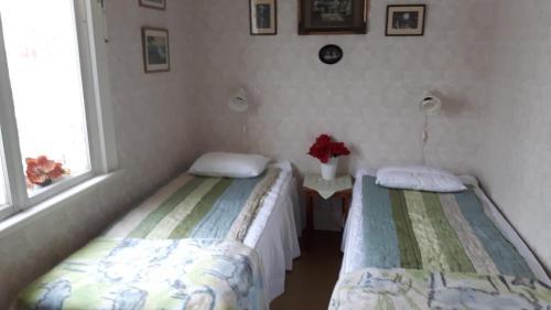 dwa łóżka w pokoju z dwoma oknami w obiekcie Lottas Rum w mieście Smedjebacken