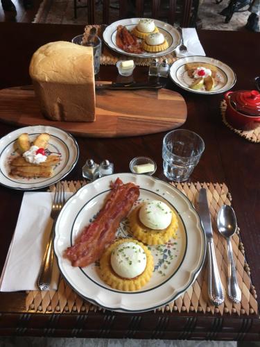 una mesa de madera con platos de comida. en Elkwood Manor Bed & Breakfast, en Pagosa Springs
