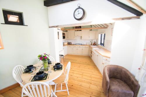 a kitchen with a table and chairs and a clock at The Stables in Southwell in Southwell