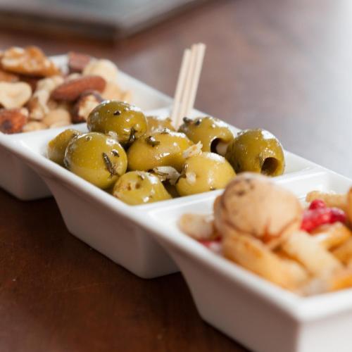 a plate of food with olives and other foods on a table at Hotel Verhoeven in Uden
