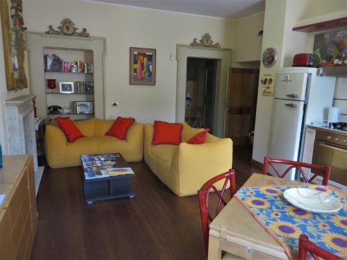 a living room with a yellow couch and red pillows at La Casa nel Borgo in Torre Orsina