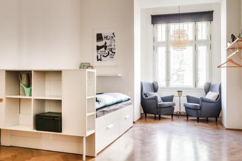 ein kleines Zimmer mit einem Bett und zwei Stühlen in der Unterkunft Trendy Local Apartment in Prag