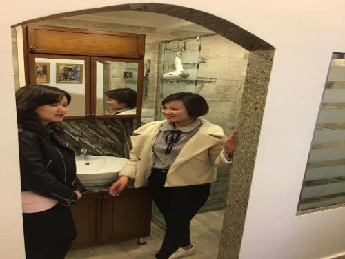 two women standing in front of a bathroom mirror at Paris Hotel Cairo in Cairo