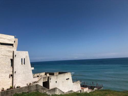 a building with the ocean in the background at Beach Shoes Villa in Yanliau