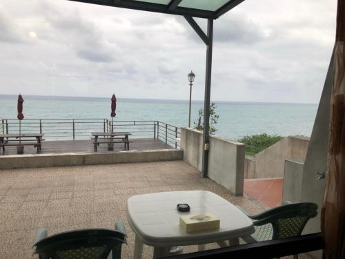 a table and chairs on a balcony overlooking the ocean at Beach Shoes Villa in Yanliau