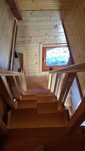 a staircase in a wooden cabin with a window at Holiday Home Perduh in Sekulić 