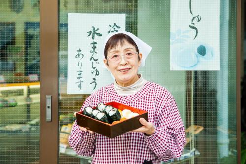 a woman is holding a box of vegetables at Bamba Hotel Tokyo-Private Townhouse- in Tokyo