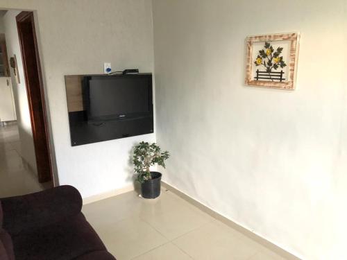 sala de estar con TV en una pared blanca en Casas Label - Hospedagem São Thomé, en São Thomé das Letras