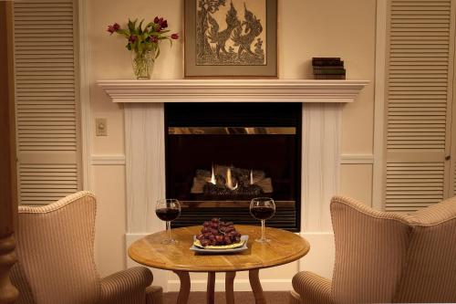 a table with two glasses of wine and a fireplace at Eagle Harbor Inn in Ephraim