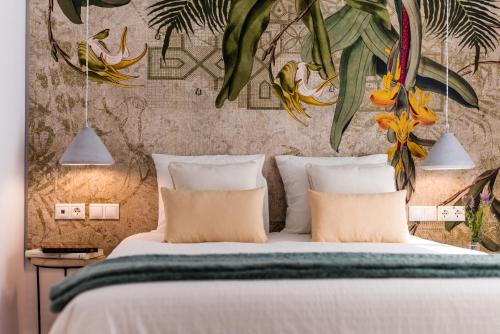 1 dormitorio con 1 cama con pared de flores en FerAla Suites Centro B, en Granada