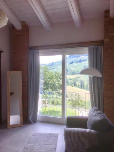 a living room with a large window and a couch at Casa Visette in Monforte dʼAlba
