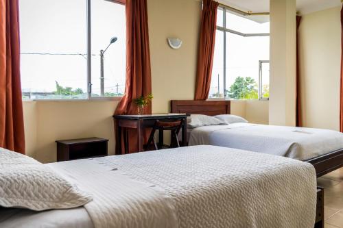 a hotel room with three beds and a desk at Hotel Palmar del Río Premium in Archidona