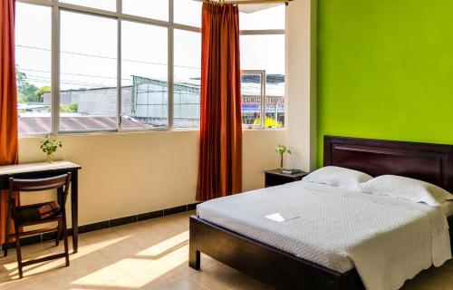 a bedroom with a bed and a green wall at Hotel Palmar del Río Premium in Archidona