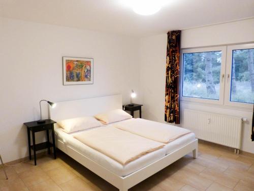 ein Schlafzimmer mit einem weißen Bett und einem Fenster in der Unterkunft Ferienwohnung *Wibkes Hüs* in Wittdün